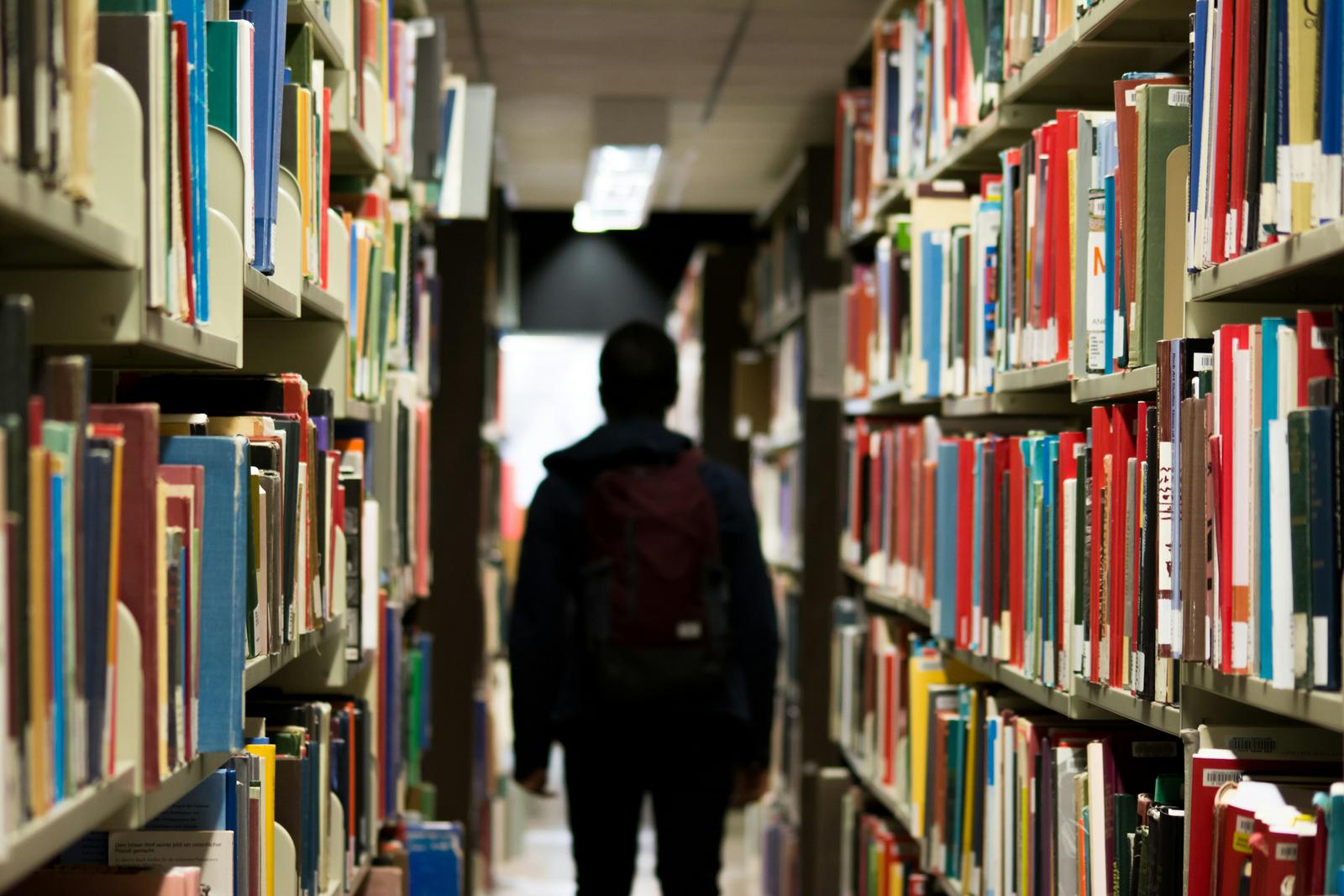 A university library aisle — the deep research behind TraderMerit